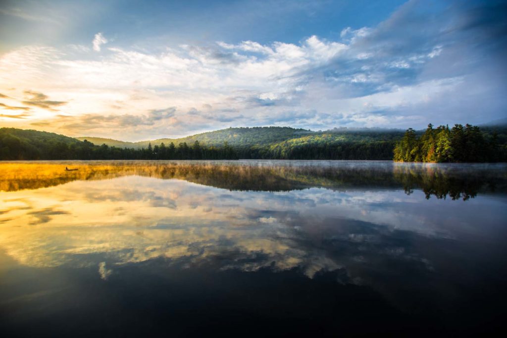 image of morning sun over a lake view scene with sun hitting the distance landscape