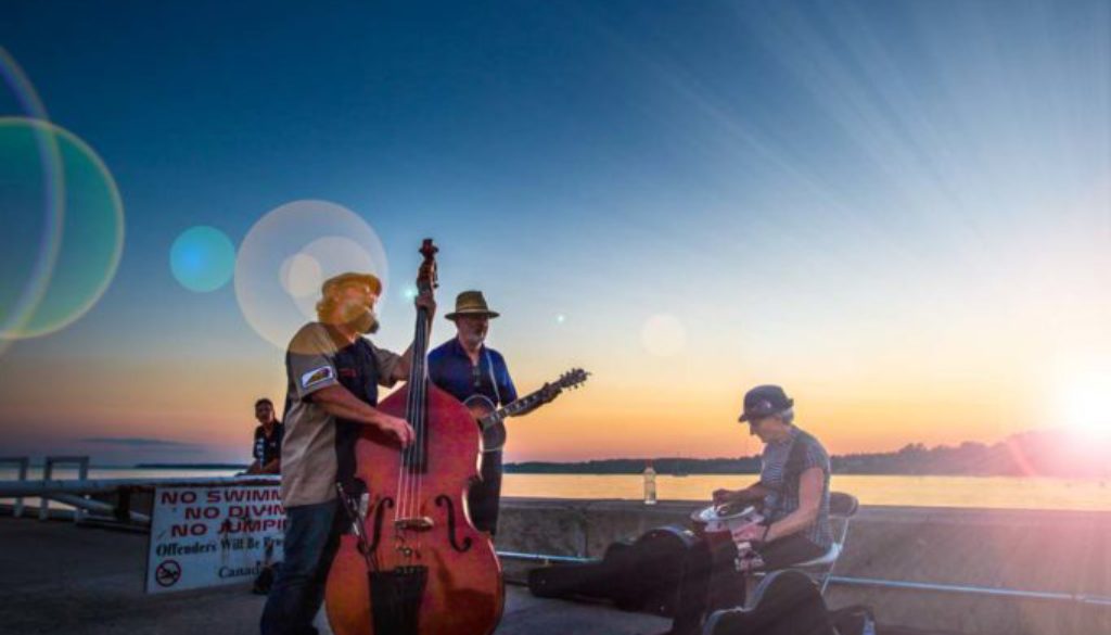 image of folk band singing in front of a beautiful sunset in port dover ontario